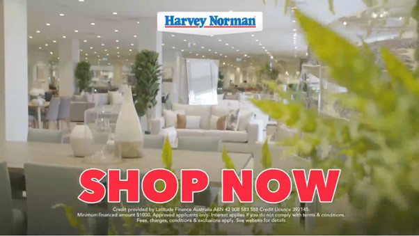 Harvey Norman store interior with "Shop Now" call to action